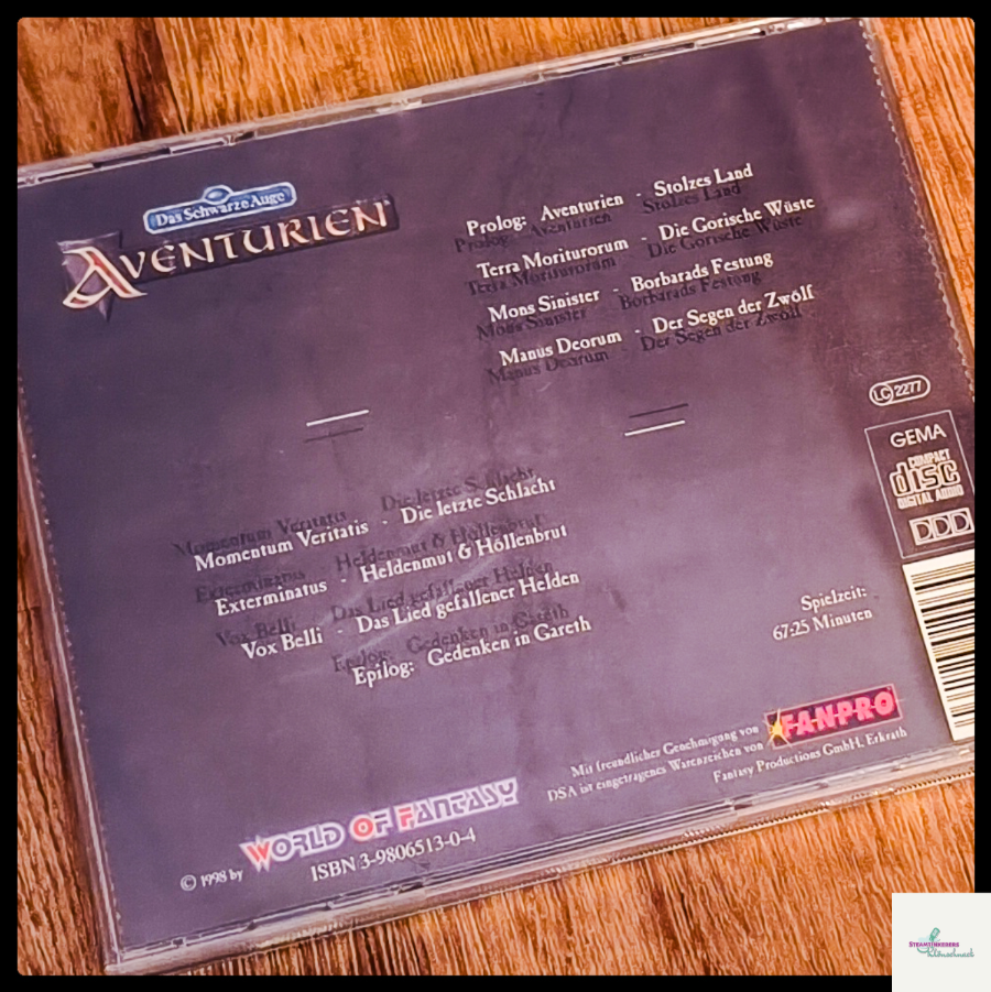 Die Hülle der "Aventurien Rollenspiel Konzept-CD" liegt auf einem hölzernen Untergrund. Oben ist die Rückseite zu sehen.