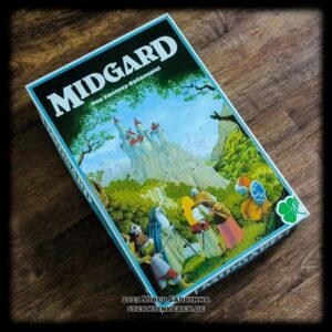 Die Grundbox der 3. Edition von "MIDGARD - Das Fantasy-Rollenspiel" liegt auf einem hölzernen Untergrund.